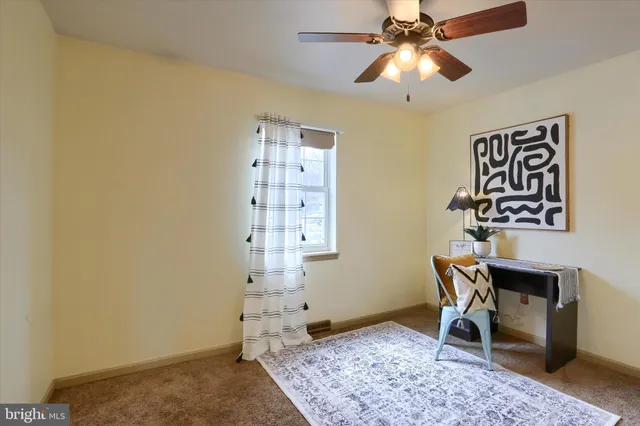a view of a workspace with furniture and chandelier fan