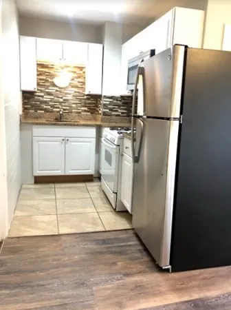 a kitchen with stainless steel appliances granite countertop a refrigerator and a stove