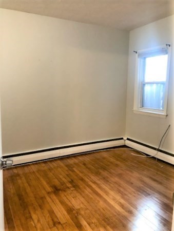 10 Fourth St Place, Unit 1 Cambridge, MA 02141 - Photo 4 of 6 a view of an empty room with wooden floor and a window