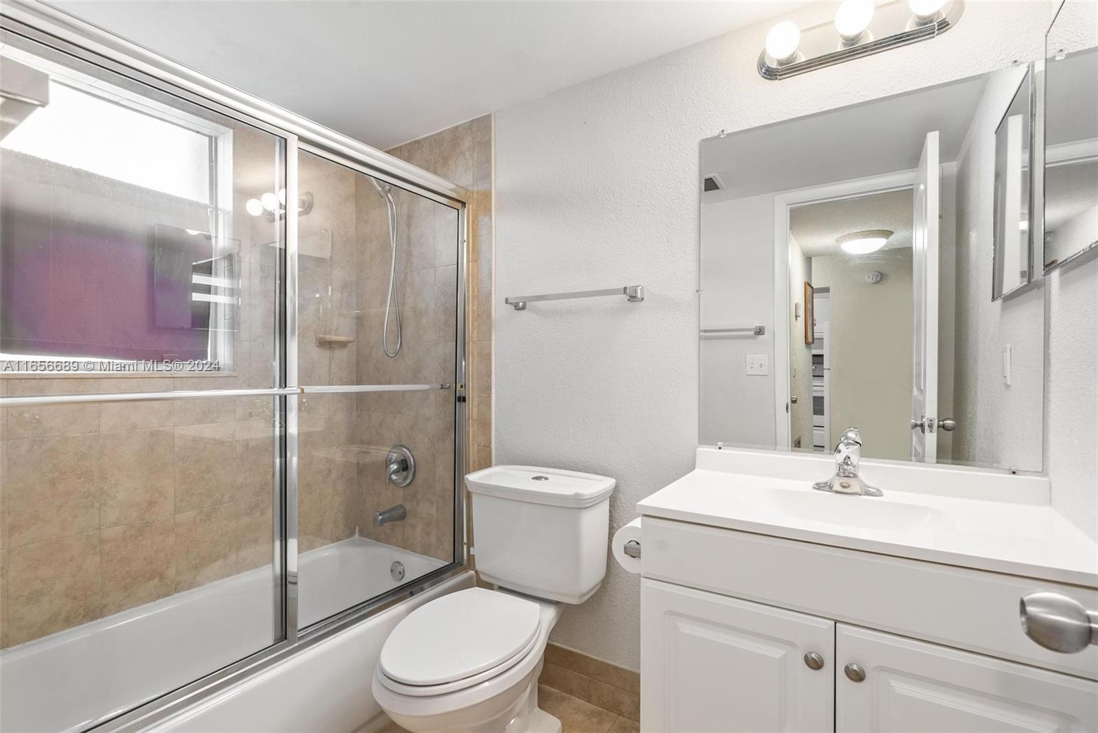 440 Southeast 2nd Avenue, Unit 3 Deerfield Beach, FL 33441 - Photo 7 of 14 a bathroom with a toilet a sink a glass door a shower and a mirror
