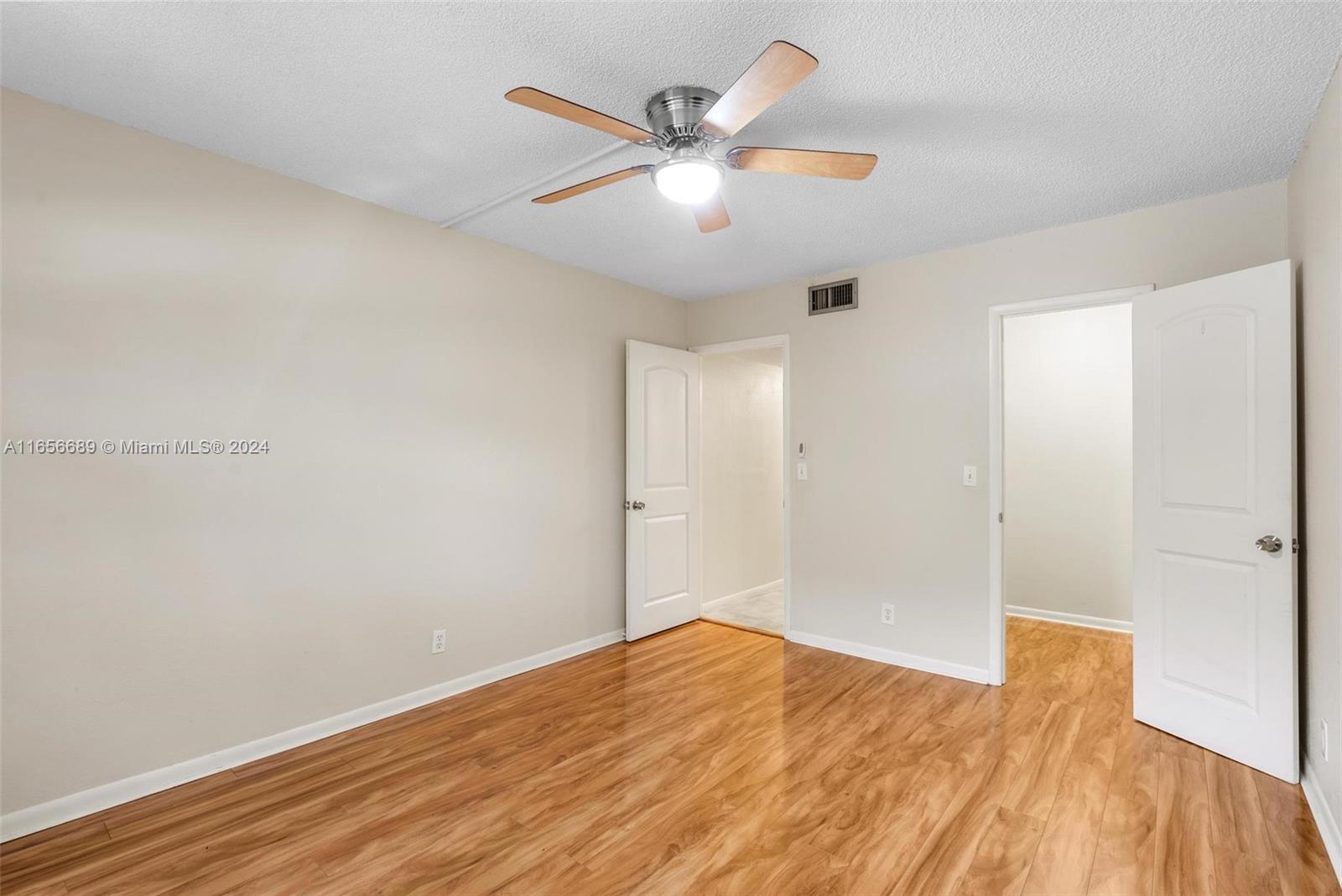 440 Southeast 2nd Avenue, Unit 3 Deerfield Beach, FL 33441 - Photo 9 of 14 an empty room with wooden floor and ceiling fan