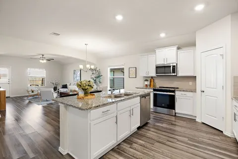 a kitchen with sink stove and cabinets