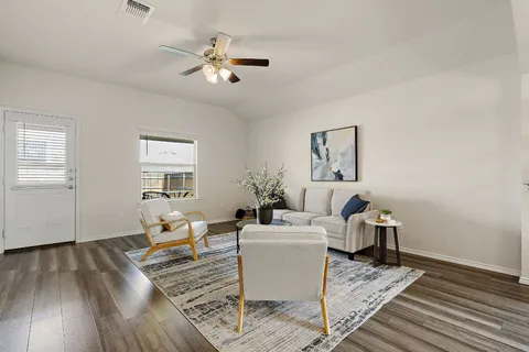 a living room with furniture and a wooden floor