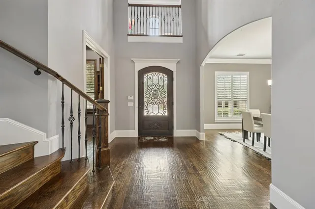 a view of a hallway with wooden floor stairs