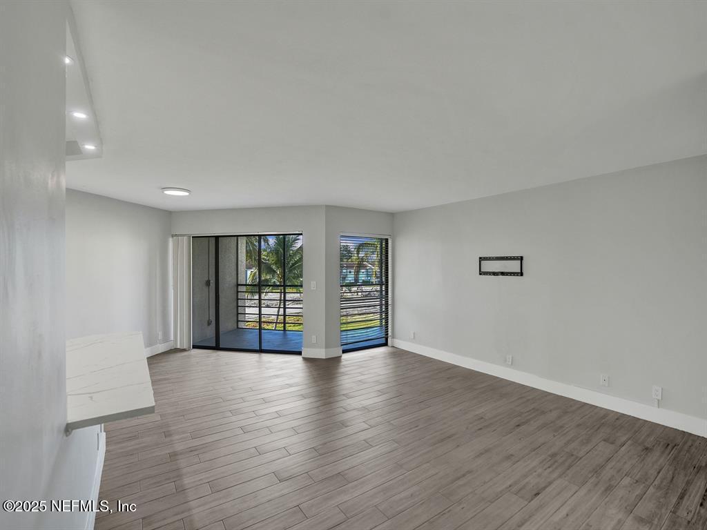 5851 Camino Del Sol, Unit 305 Boca Raton, FL 33433 - Photo 14 of 47 a view of an empty room with wooden floor and a window