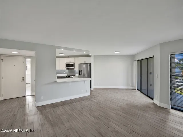 a view of a kitchen with wooden floor and a sink