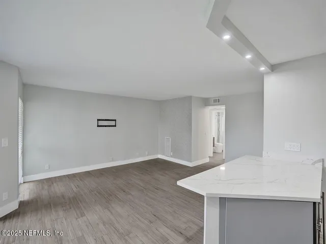 a view of an empty room with wooden floor