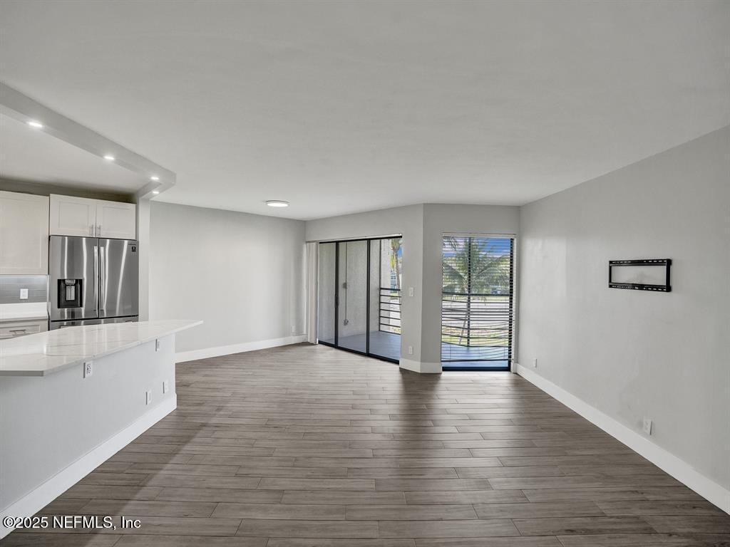 5851 Camino Del Sol, Unit 305 Boca Raton, FL 33433 - Photo 20 of 47 a view of an empty room with wooden floor and a window