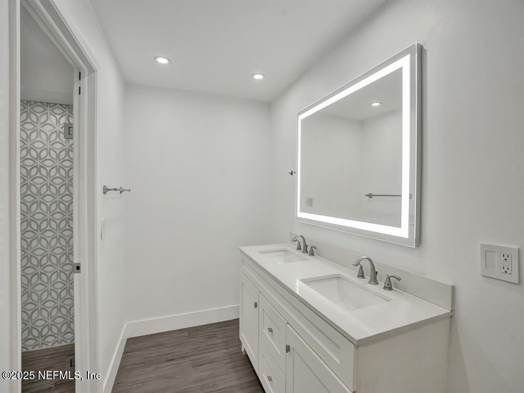 5851 Camino Del Sol, Unit 305 Boca Raton, FL 33433 - Photo 26 of 47 a bathroom with a sink a mirror and a shower