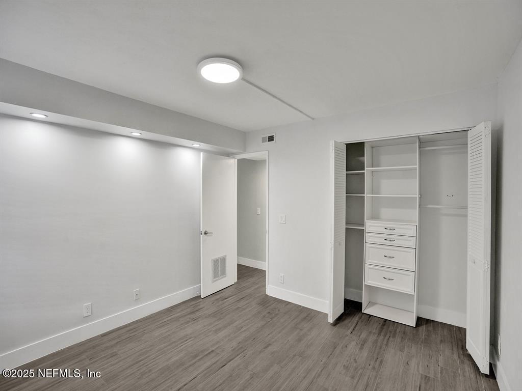 5851 Camino Del Sol, Unit 305 Boca Raton, FL 33433 - Photo 30 of 47 a view of an empty room with closet and wooden floor