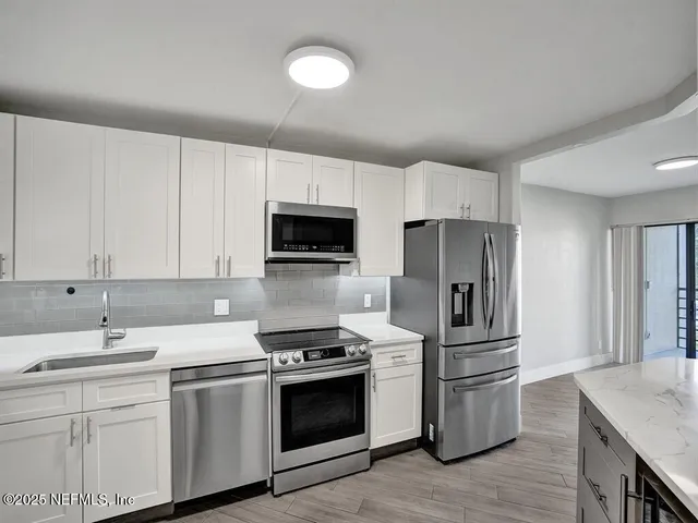 a kitchen with a sink appliances and cabinets