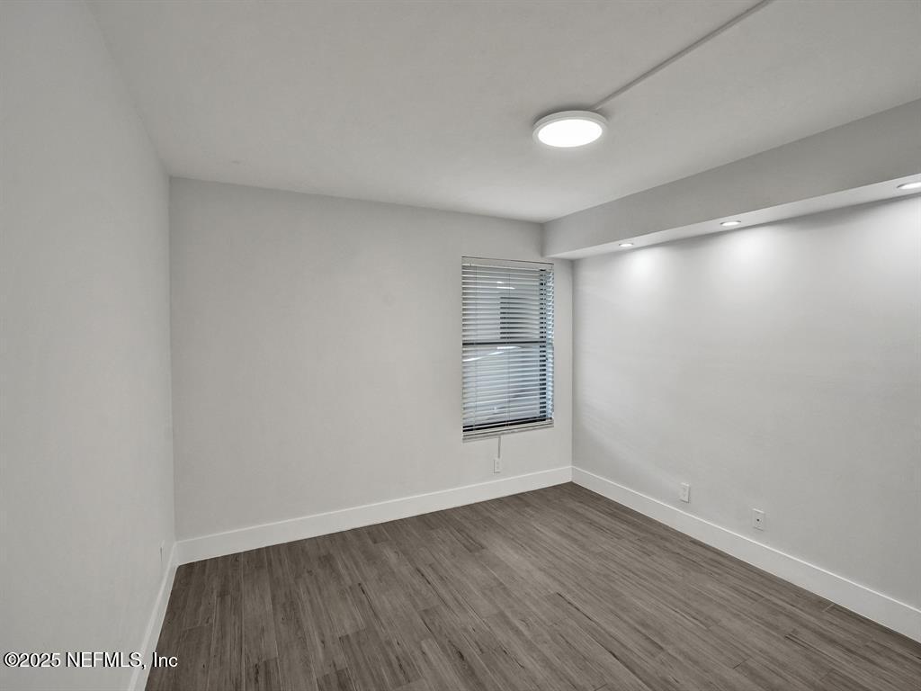 5851 Camino Del Sol, Unit 305 Boca Raton, FL 33433 - Photo 32 of 47 an empty room with wooden floor and windows