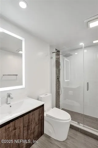 a bathroom with a sink a toilet and shower