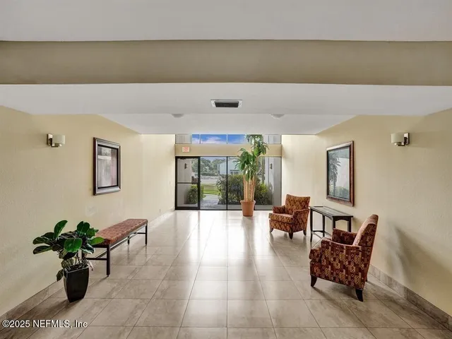 a living room with furniture and potted plants
