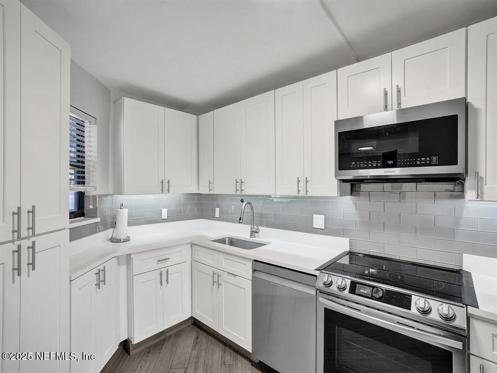 5851 Camino Del Sol, Unit 305 Boca Raton, FL 33433 - Photo 5 of 47 a kitchen with a sink stove and microwave