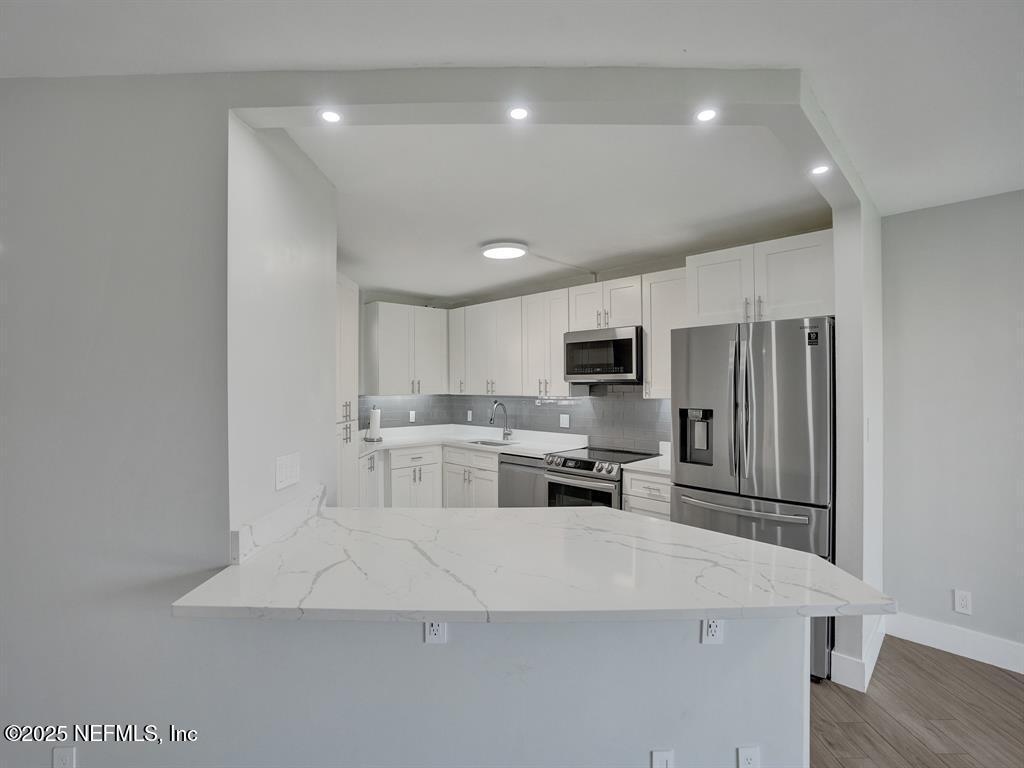 5851 Camino Del Sol, Unit 305 Boca Raton, FL 33433 - Photo 8 of 47 a kitchen with stainless steel appliances a refrigerator sink and microwave