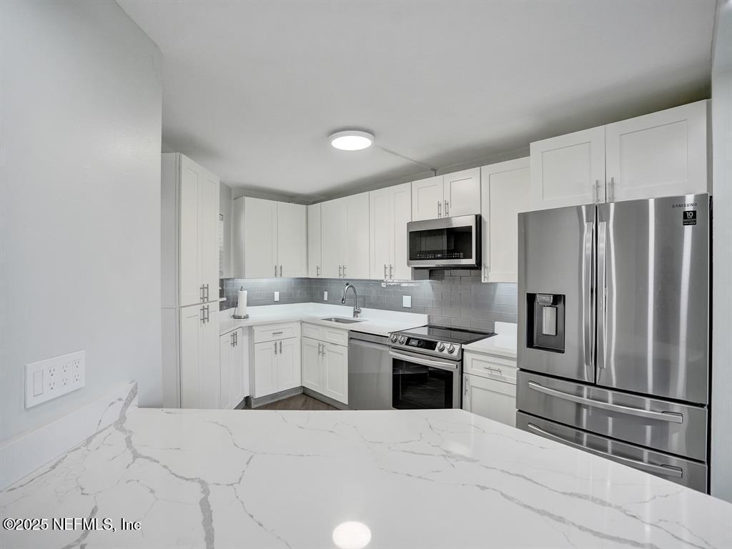 5851 Camino Del Sol, Unit 305 Boca Raton, FL 33433 - Photo 9 of 47 a kitchen with a sink stainless steel appliances and white cabinets