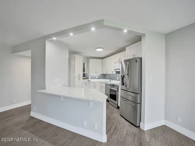 a kitchen with refrigerator and cabinets