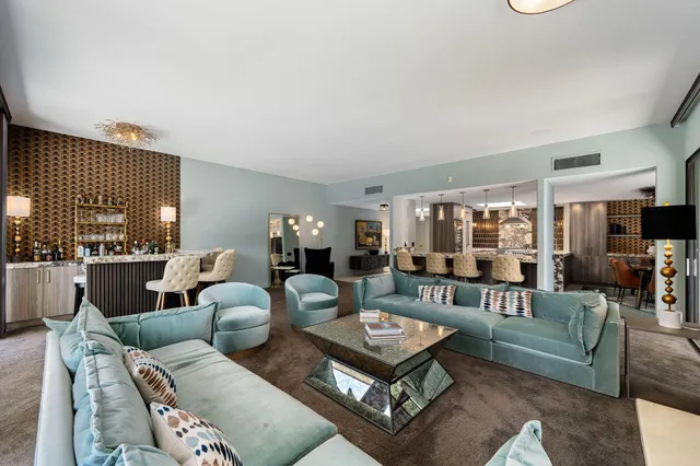 a living room with furniture and a view of kitchen