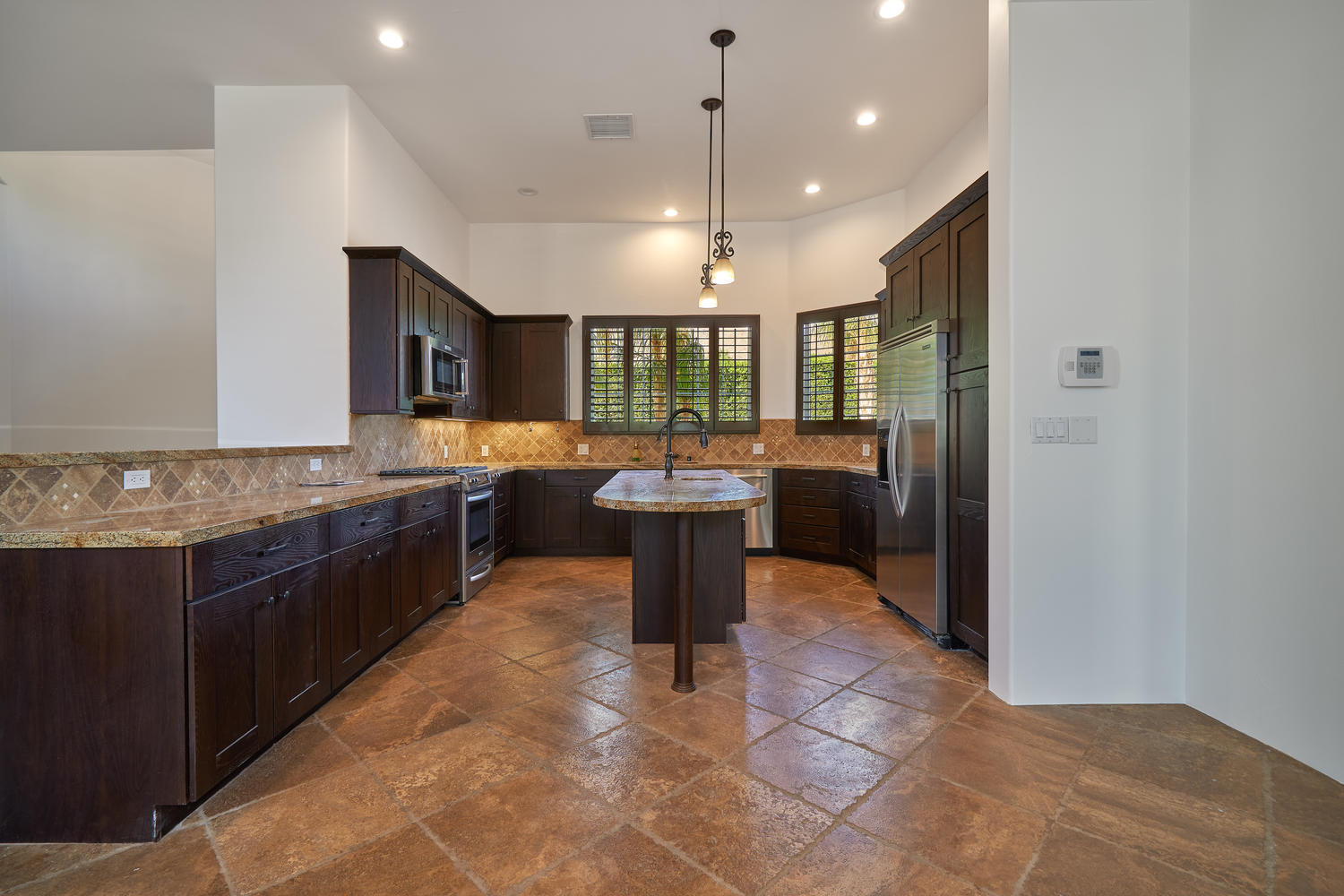 695 West Racquet Club Road Palm Springs, CA 92262 - Photo 15 of 50 a large kitchen with a large counter top a sink stainless steel appliances and cabinets