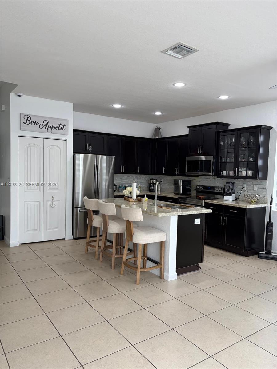 24982 Southwest 118th Court Homestead, FL 33032 - Photo 30 of 51 a kitchen with stainless steel appliances kitchen island granite countertop a sink and cabinets