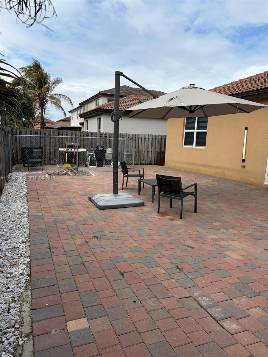 24982 Southwest 118th Court Homestead, FL 33032 - Photo 43 of 51 a roof deck with table and chairs under an umbrella