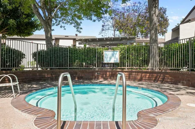 a view of a swimming pool with a patio and a backyard