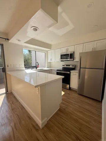 a kitchen with stainless steel appliances granite countertop a refrigerator a stove a sink dishwasher and a refrigerator