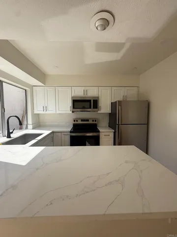 a large kitchen with cabinets and stainless steel appliances