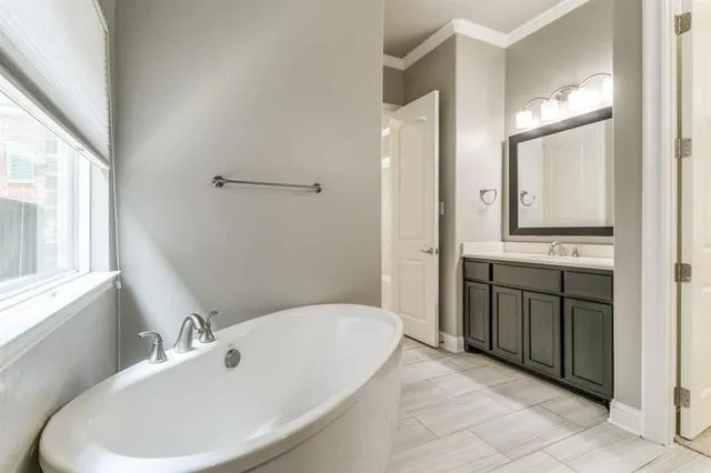 a bathroom with a tub sink and mirror