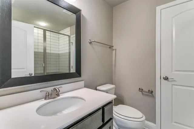 a bathroom with a sink toilet vanity and shower