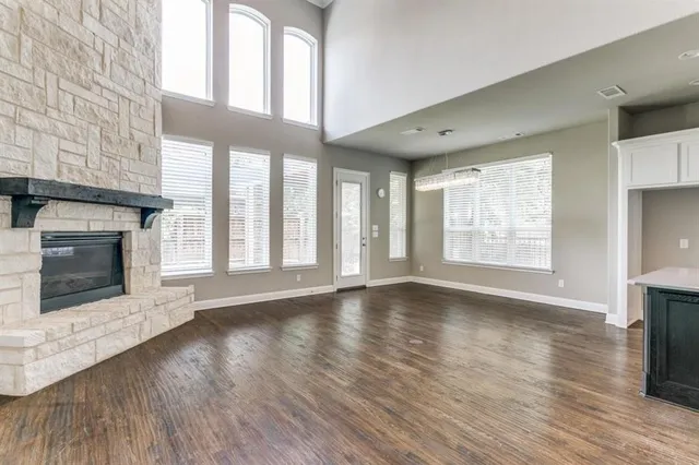 wooden floor fireplace and windows in an empty room
