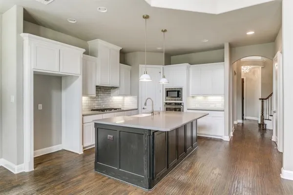 a kitchen with stainless steel appliances a refrigerator a sink and wooden cabinets