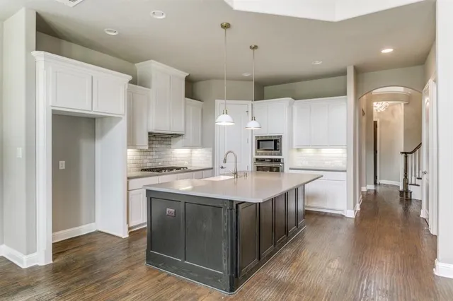 a kitchen with stainless steel appliances a refrigerator a sink and wooden cabinets