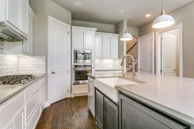 a kitchen with kitchen island a sink appliances and cabinets