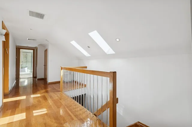 a view of a hallway with wooden floor and entryway