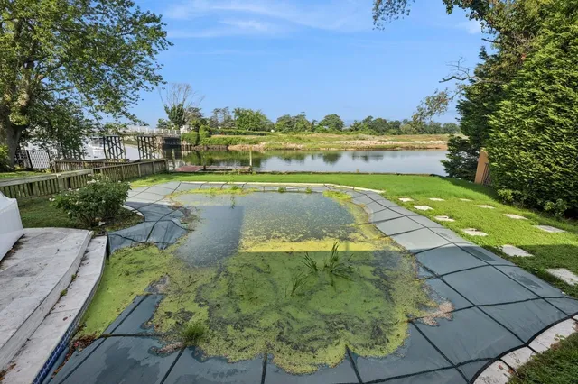 a view of a swimming pool with a lawn chairs and a fire pit