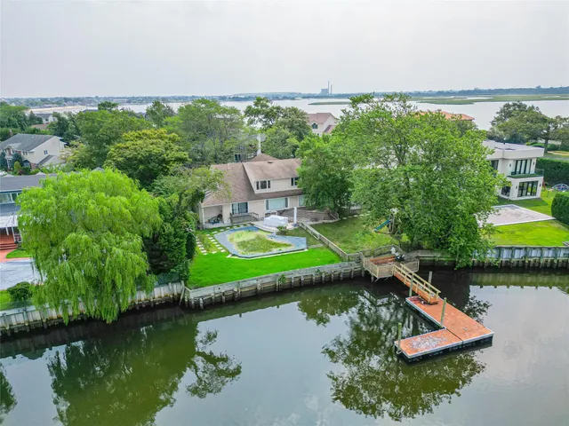 an aerial view of a house with a garden and lake view