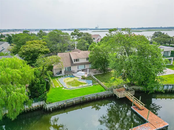 an aerial view of a house with a garden and lake view