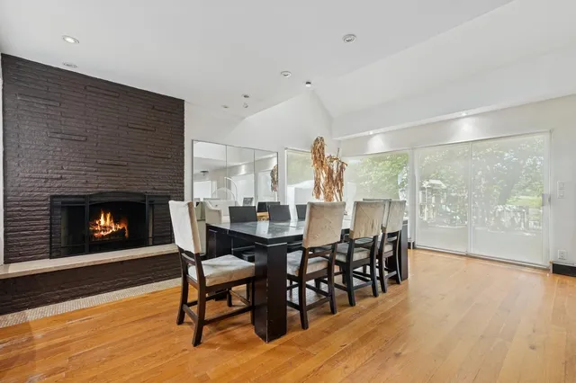 a dining room with furniture a fireplace and wooden floor