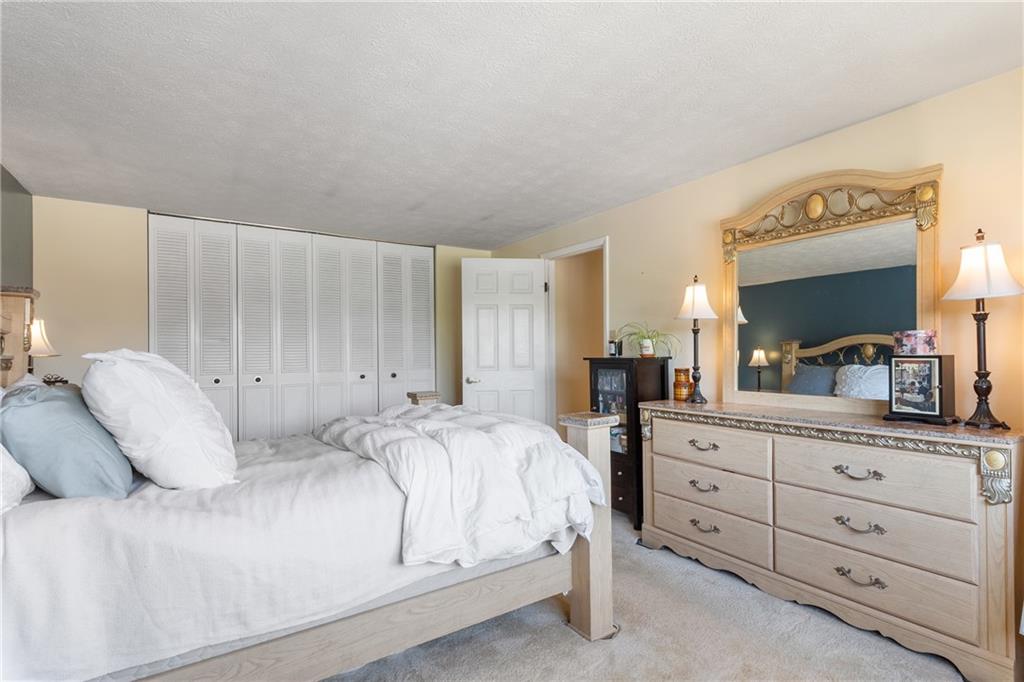 329 Ridge Point Circle, Unit 33 Bridgeville, PA 15017 - Photo 15 of 32 a bedroom with a large bed and a dresser