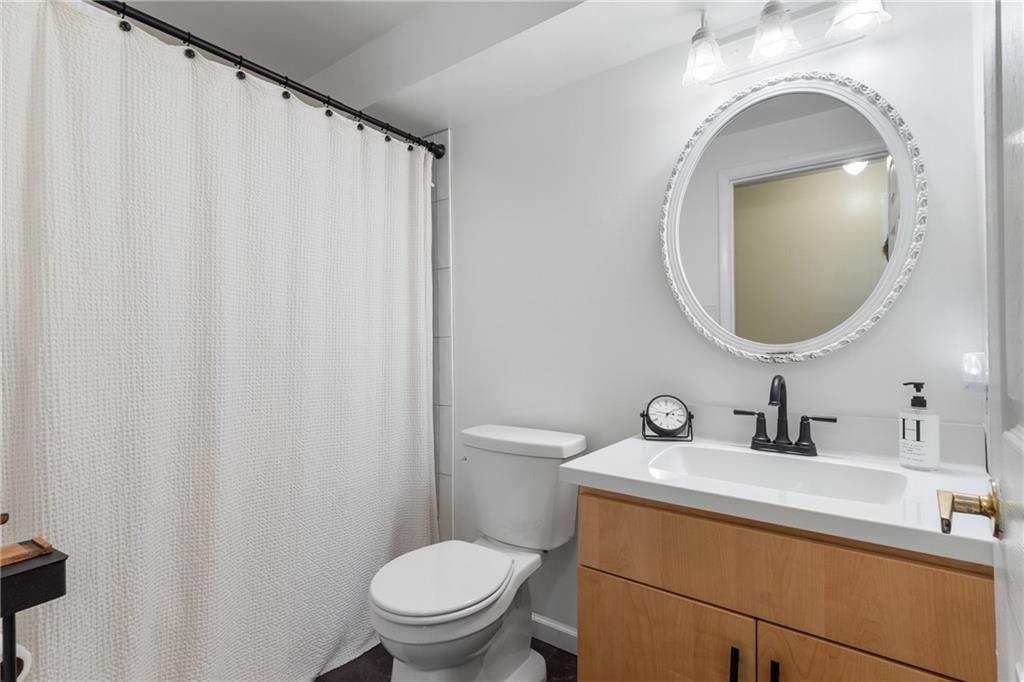 329 Ridge Point Circle, Unit 33 Bridgeville, PA 15017 - Photo 16 of 32 a bathroom with a sink a toilet and a mirror