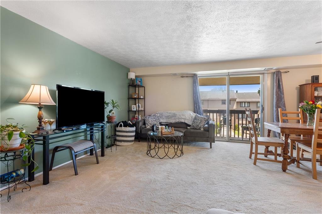 329 Ridge Point Circle, Unit 33 Bridgeville, PA 15017 - Photo 6 of 32 a living room with furniture and a flat screen tv