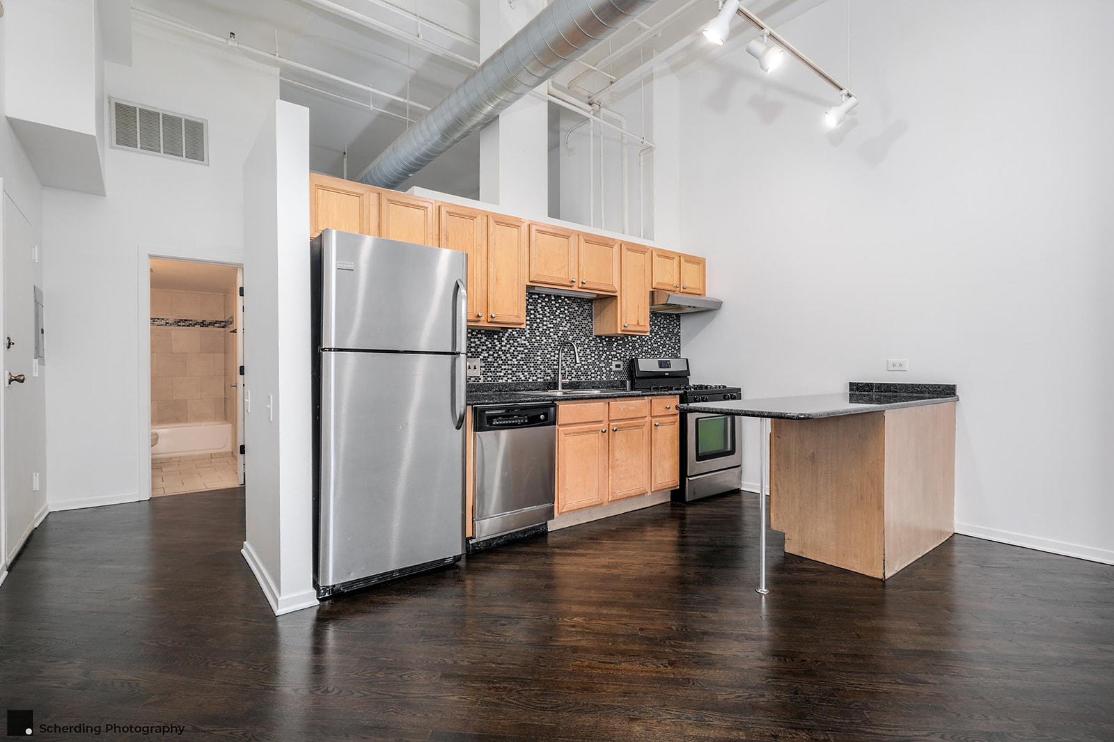 500 South Clinton Street, Unit 130 Chicago, IL 60607 - Photo 6 of 17 a kitchen with a refrigerator and white cabinets