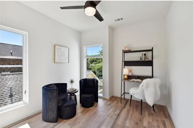 a view of an empty room with window and wooden floor