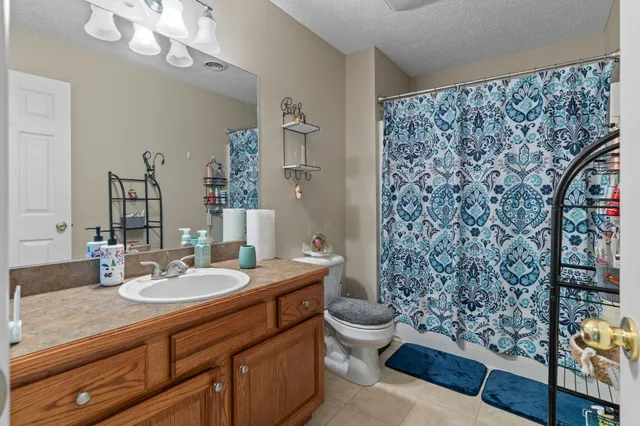 a bathroom with a sink a toilet and shower curtain