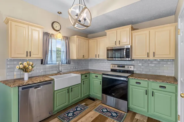 a kitchen with cabinets a window and stainless steel appliances