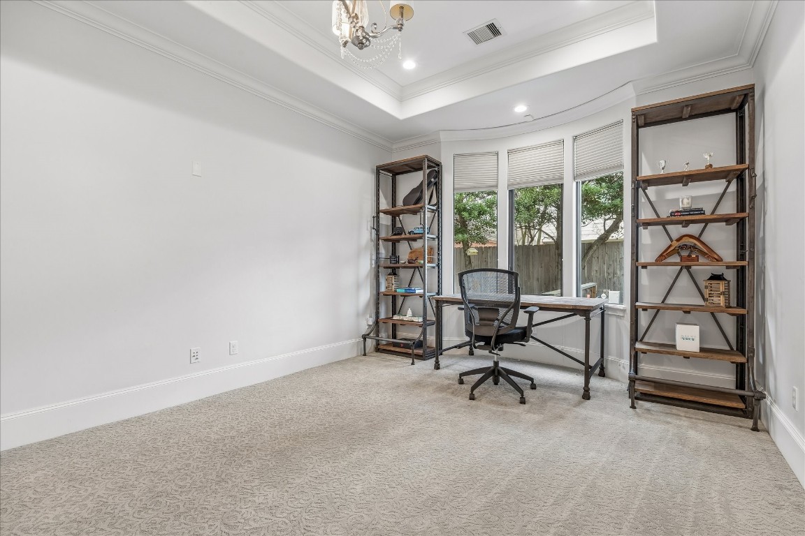 4022 Coleridge Street Houston, TX 77005 - Photo 14 of 31 Spacious junior suite (on first floor with ensuite bathroom). Currently, the room is utilized for a home office with large windows overlooking the backyard, crown molding, plush designer carpet, and neutral finishes ideal for working from home.