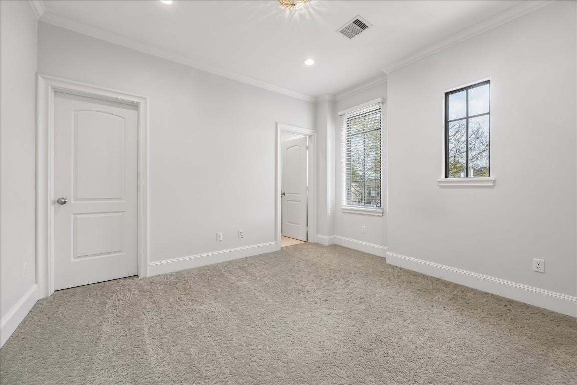 4022 Coleridge Street Houston, TX 77005 - Photo 22 of 31 Bright secondary bedroom featuring plush designer carpet, crown molding, and oversized windows.