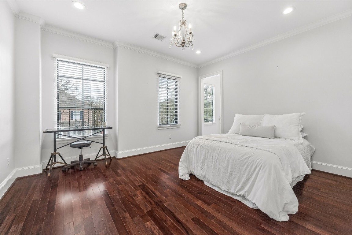 4022 Coleridge Street Houston, TX 77005 - Photo 24 of 31 Spacious bedroom with tray ceiling, hardwood floors, and soft natural light.